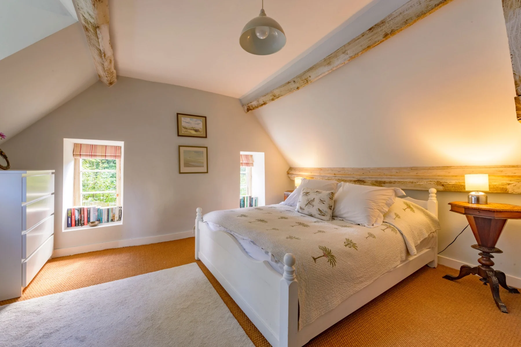 First guest bedroom with a white king-size bed beneath timber beams
