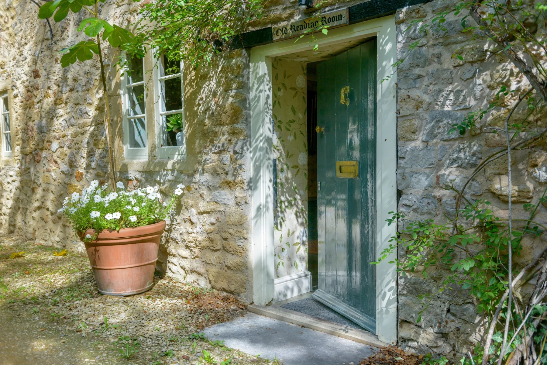 The open front door of the Old Reading Room, with flowers and a glimpse of the hall